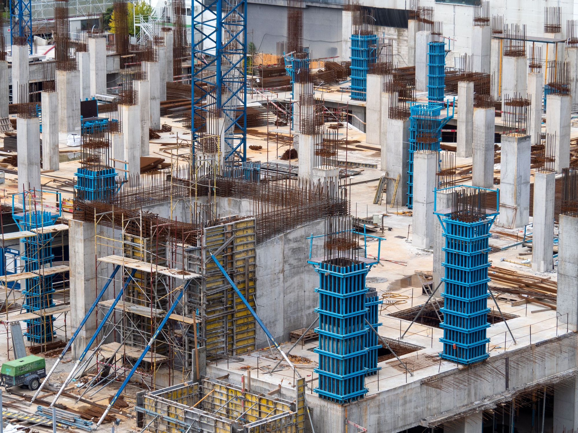 Urban construction site with concrete pillars and formwork.